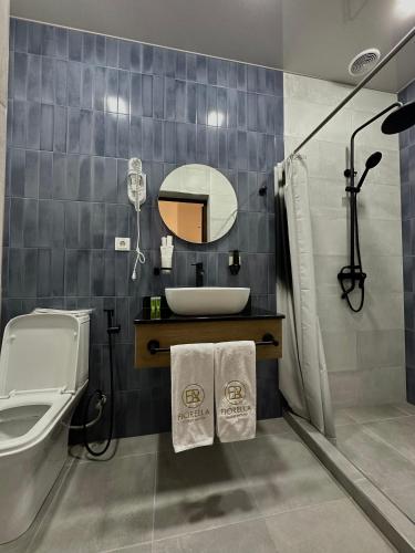 a bathroom with a sink and a toilet and a mirror at Fiorella Gyumri in Gyumri