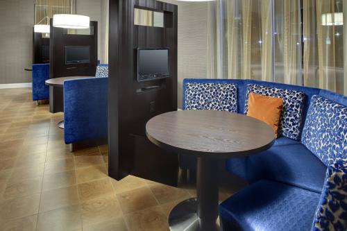 a dining room with a blue couch and a table at Courtyard by Marriott Boone in Boone