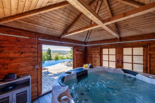 einen großen Whirlpool in einem Holzzimmer mit Pool in der Unterkunft Ferrabouc in Mas-Saintes-Puelles