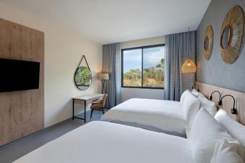 a hotel room with two beds and a window at Protea Hotel by Marriott Ndola in Ndola