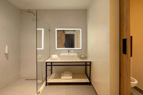 a bathroom with a sink and a mirror at Protea Hotel by Marriott Ndola in Ndola