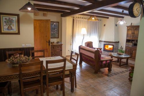 Una sala de estar con mesa y sillas y una chimenea. en Casa Rural Arroal, en Sotoserrano