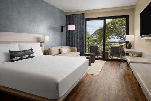 ワイレアにあるAC Hotel by Marriott Maui Waileaの大きな白いベッドとリビングルームのある寝室