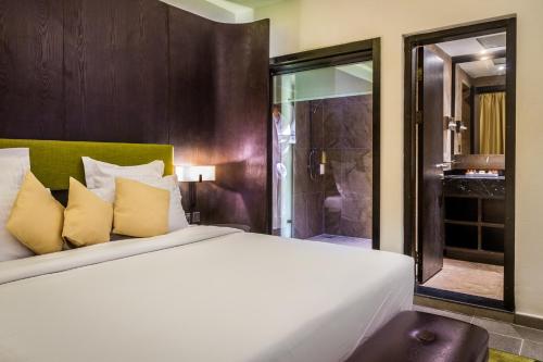 a bedroom with a large white bed and a shower at Azalaï Hôtel Nouakchott in Nouakchott