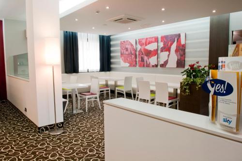 a dining room with white tables and white chairs at Hotel Gardenia in Romano Canavese