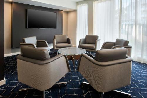 a waiting room with chairs and a table and a flat screen tv at Courtyard by Marriott Rye in Rye