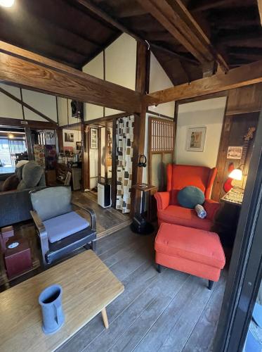 a living room with a red couch and a table at Okawachiyama LODGE - Village of the Secret Kilns! in Imari