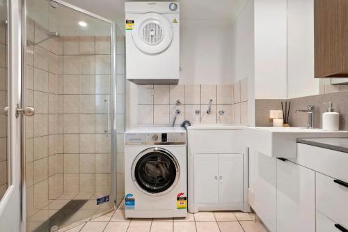 a washer and dryer in a white kitchen at Melbourne Street Haven in North Adelaide