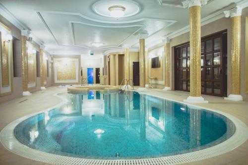 a large swimming pool in a hotel room at Forgách Kastély in Mándok