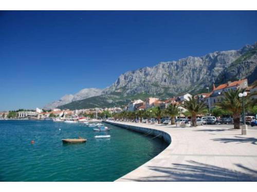 a body of water with boats in it with mountains at Apartments Elda in Makarska
