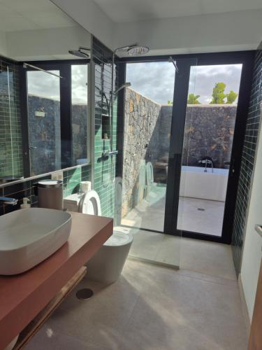 a bathroom with a sink and a tub and a toilet at Villa Lavayarena private pool in Lajares in La Oliva
