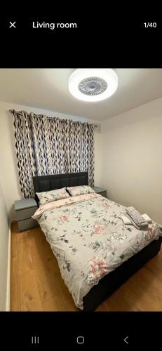 a bedroom with a bed with a floral bedspread at South West London semi-detached House in Mitcham