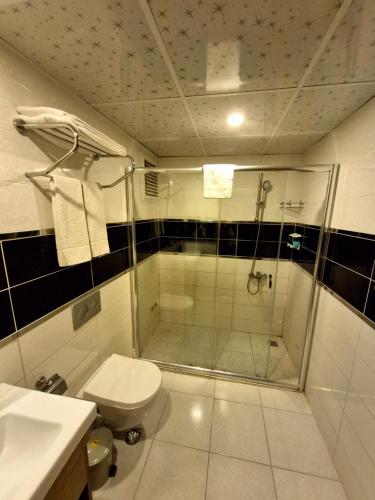 a bathroom with a shower and a toilet at Toprak Otel in Antalya