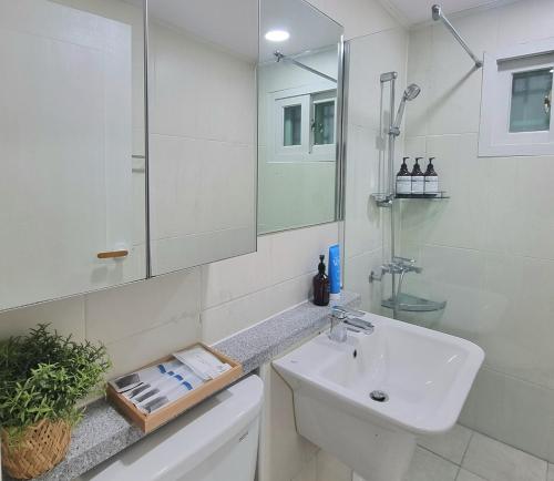 a white bathroom with a sink and a mirror at Dal126 House Seoul in Seoul