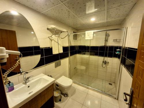 a bathroom with a shower and a toilet and a sink at Toprak Otel in Antalya