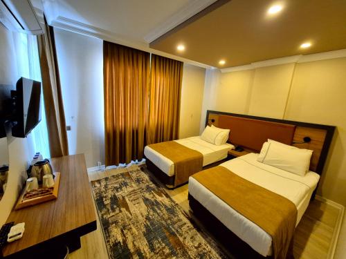 a hotel room with two beds and a table at Toprak Otel in Antalya