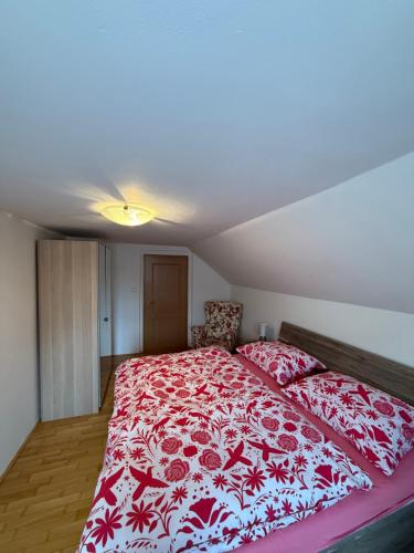 a bedroom with a bed with a red and white blanket at Dům FAUNA V Českosaském Švýcarsku in Janov