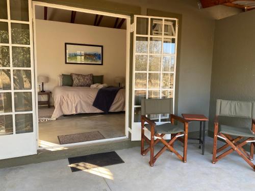 una camera da letto con un letto, un tavolo e delle sedie di Murchison View Cottage a Gravelotte
