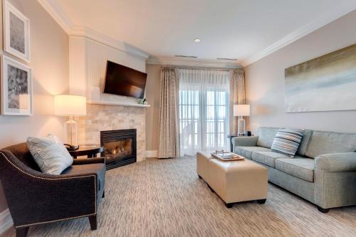 a living room with a couch and a fireplace at Inn at Bay Harbor, Autograph Collection in Petoskey