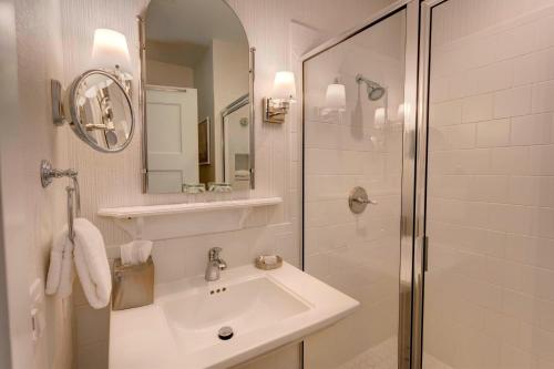 a white bathroom with a sink and a shower at Inn at Bay Harbor, Autograph Collection in Petoskey