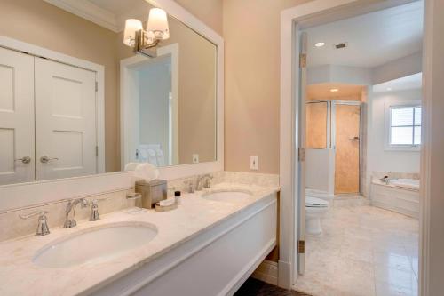 a bathroom with two sinks and a large mirror at Inn at Bay Harbor, Autograph Collection in Petoskey