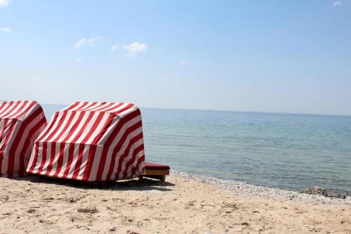 two beach umbrellas sitting on a sandy beach at Inn at Bay Harbor, Autograph Collection in Petoskey