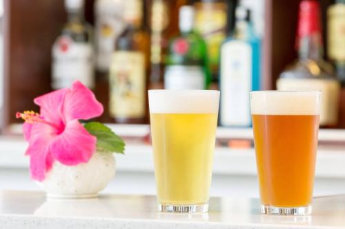 two glasses of beer on a counter with a flower at Courtyard by Marriott Waikiki Beach in Honolulu