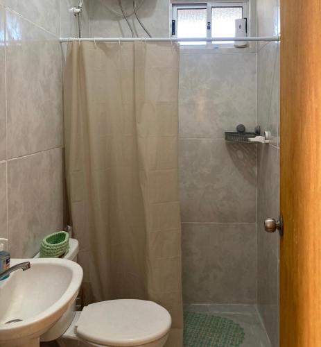 a bathroom with a shower and a toilet and a sink at cabaña NFF in Punta Del Diablo