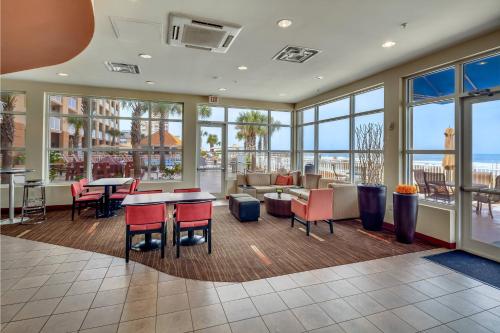 a lobby with tables and chairs and a view of the ocean at Courtyard by Marriott Jacksonville Beach Oceanfront in Jacksonville Beach