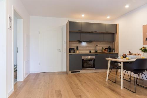 a kitchen and dining room with a table and chairs at living TIMELESS - Adler Apartments Sasbachwalden in Sasbachwalden
