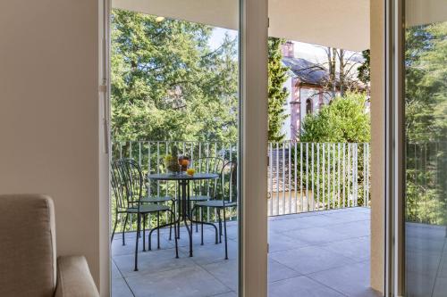 a glass door leading to a patio with a table and chairs at living TIMELESS - Adler Apartments Sasbachwalden in Sasbachwalden