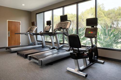 a gym with several tread machines and a large window at Courtyard by Marriott Fresno in Fresno