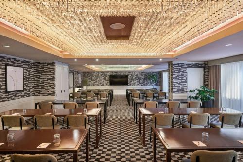a room with tables and chairs and a projection screen at The Jay, Autograph Collection in San Francisco
