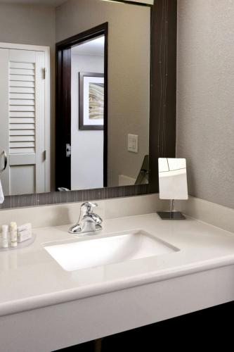a bathroom with a sink and a large mirror at Courtyard by Marriott Houston Northwest in Houston