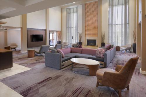 a lobby with a couch and chairs and a tv at Courtyard by Marriott Houston Northwest in Houston