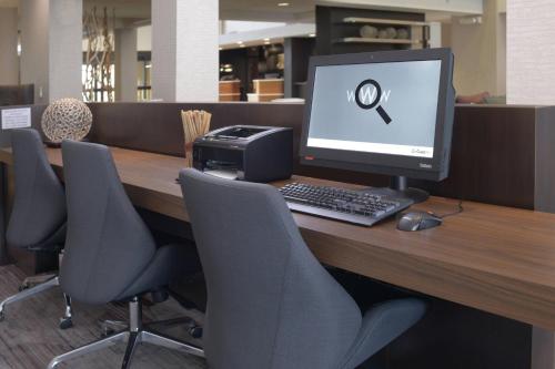 a desk with a computer monitor and a printer at Courtyard by Marriott Houston Northwest in Houston