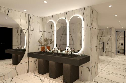 a bathroom with two sinks and mirrors on a wall at Cardo Roma, Autograph Collection in Rome