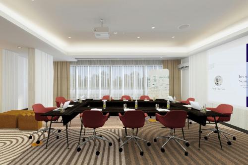 a conference room with a large table and red chairs at Cardo Roma, Autograph Collection in Rome
