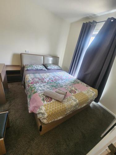 a bedroom with a bed with two towels on it at The White House Apartment in Tokoroa