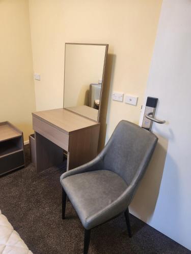 a desk with a chair and a mirror at The White House Apartment in Tokoroa