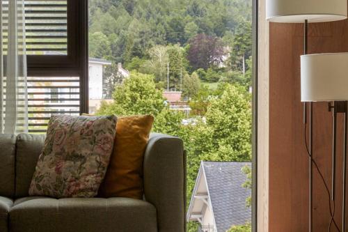 a living room with a couch and a large window at Roomers Baden-Baden, Autograph Collection in Baden-Baden