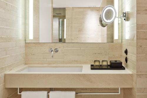 a bathroom with a large tub and a mirror at Roomers Baden-Baden, Autograph Collection in Baden-Baden