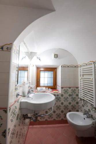 a bathroom with a sink and a tub and a toilet at La Cascina - Villa Nenno in Conca dei Marini
