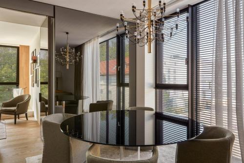 a dining room with a glass table and chairs at Roomers Baden-Baden, Autograph Collection in Baden-Baden