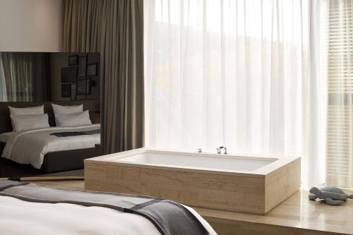 a bathroom with a bath tub in front of a window at Roomers Baden-Baden, Autograph Collection in Baden-Baden