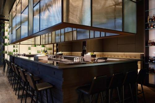 a bar with a row of stools in a restaurant at Roomers Baden-Baden, Autograph Collection in Baden-Baden