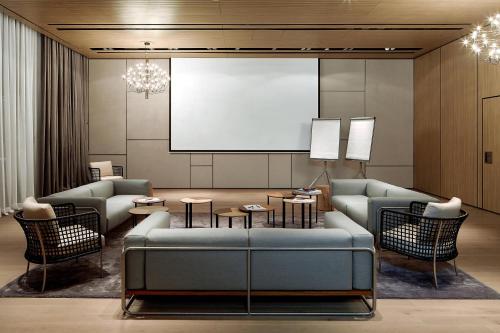 a living room with a couch and a screen at Roomers Baden-Baden, Autograph Collection in Baden-Baden