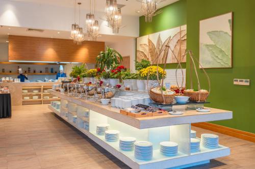 uma vitrine em um restaurante com pratos e flores em Starcity Hotel & Condotel Beachfront Nha Trang em Nha Trang