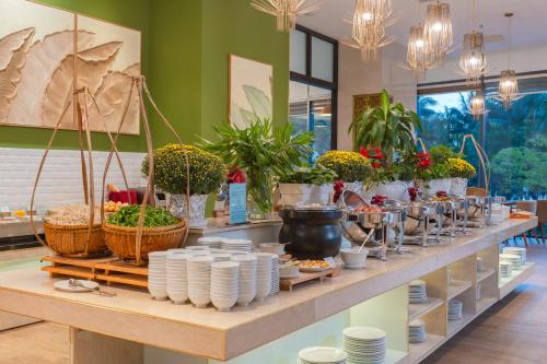 uma exposição de plantas e pratos em uma prateleira em Starcity Hotel & Condotel Beachfront Nha Trang em Nha Trang