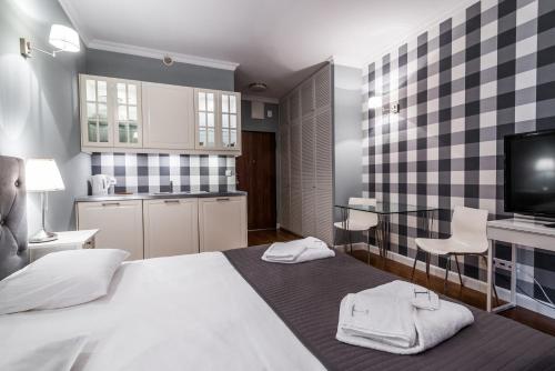 a bedroom with a bed with two towels on it at Triton Park Apartments in Warsaw